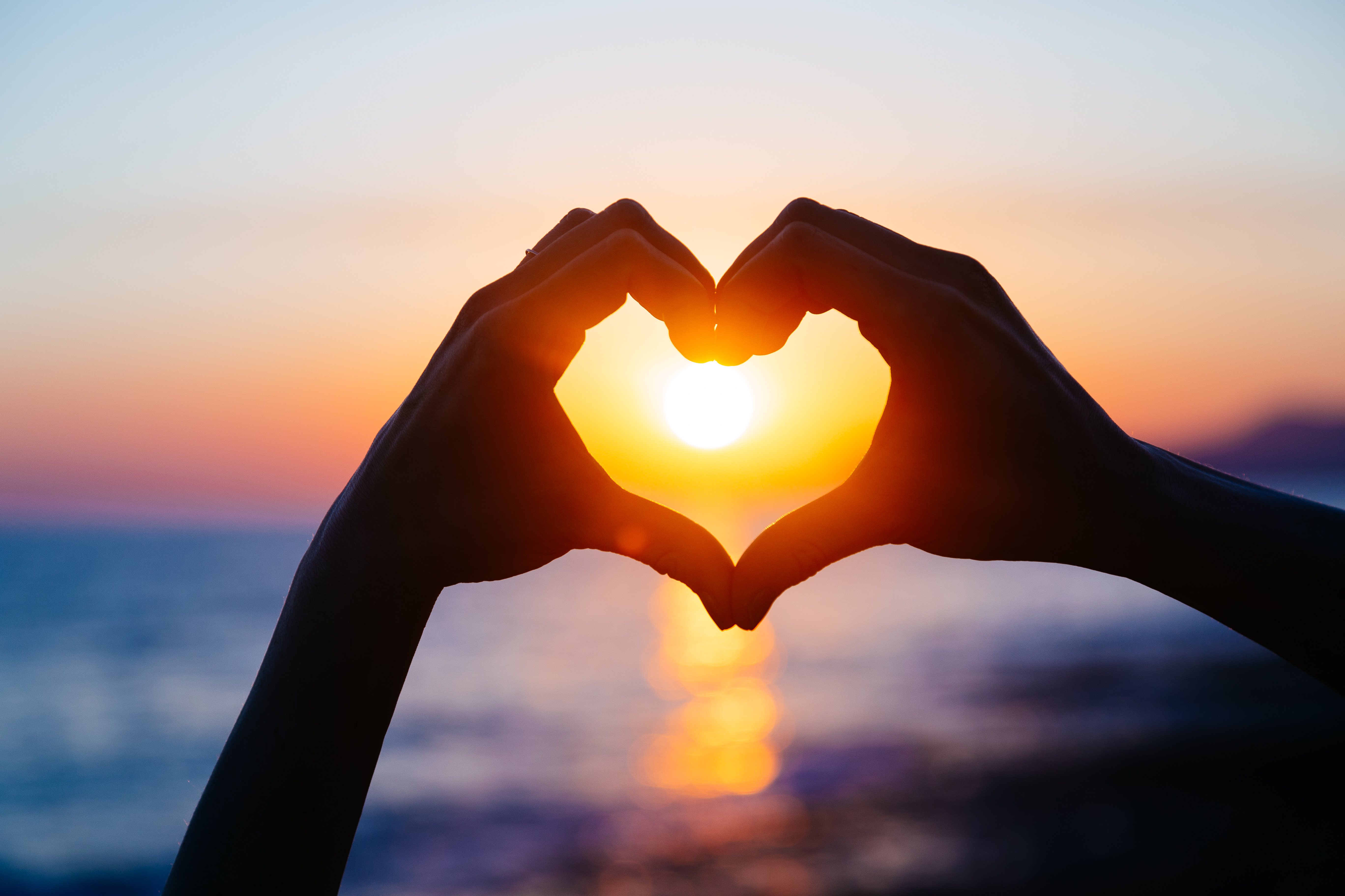 Hands Making A Heart Over A Sunset