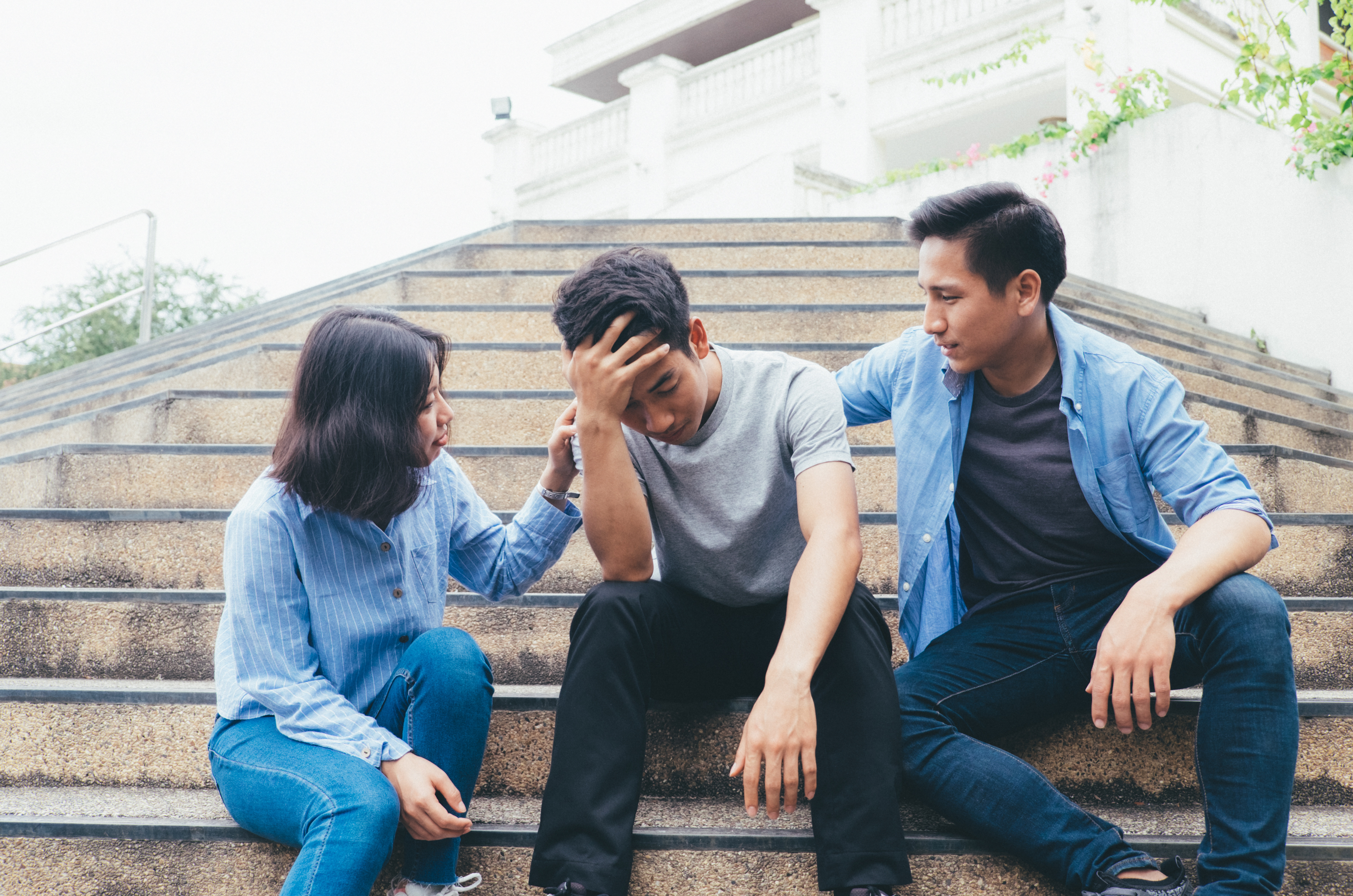 two friends supporting a friend who is in distress